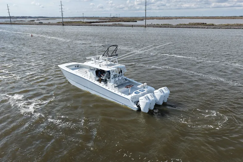 Slide: The Image of Freeman 42LR 2025 boat cruising on open water with triple outboard engines. - 14