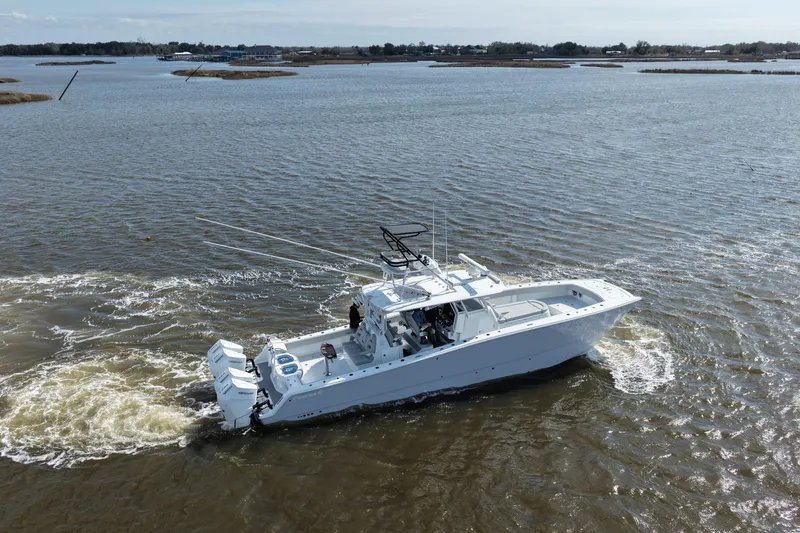 Slide: The Image of 2025 Freeman 42LR boat cruising on open water, showcasing sleek design and powerful engines. - 2