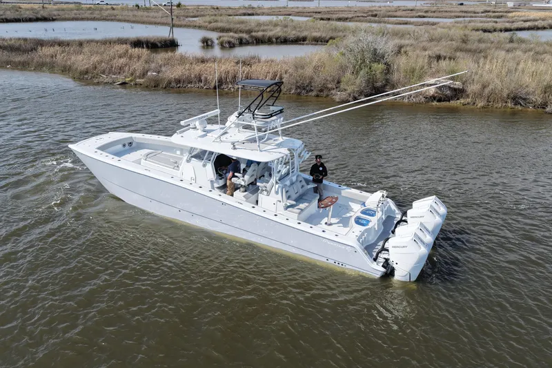 Slide: The Image of 2025 Freeman 42LR boat cruising in a calm waterway, featuring powerful Mercury engines. - 20