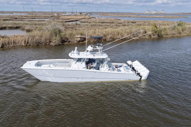 Slide: The Image of 2025 Freeman 42LR boat cruising in a scenic waterway with marshland backdrop. - 21