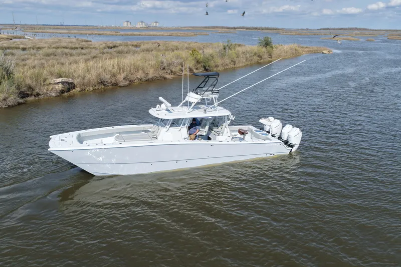 Slide: The Image of 2025 Freeman 42LR boat cruising in a scenic waterway with marshland backdrop. - 22