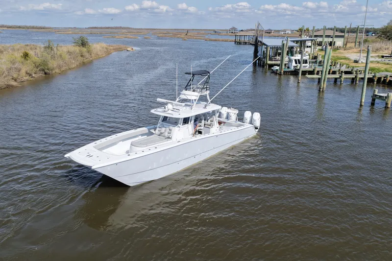 Slide: The Image of 2025 Freeman 42LR boat cruising in a scenic waterway near a dock. - 23