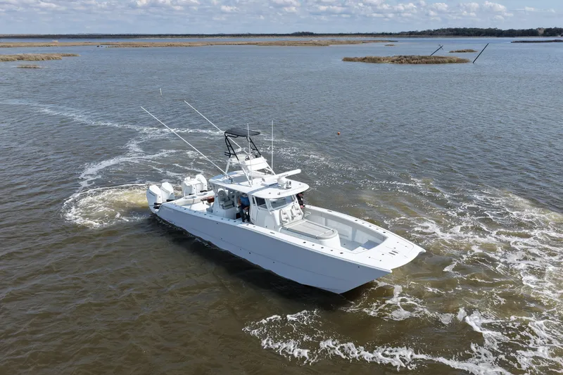 Slide: The Image of 2025 Freeman 42LR boat cruising on a calm lake with scenic background. - 4