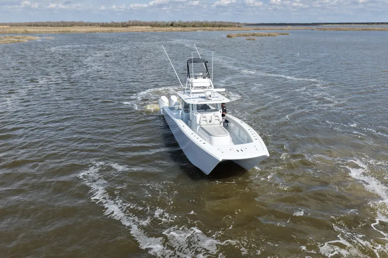 Slide: The Image of 2025 Freeman 42LR boat cruising on open water under a clear sky. - 6