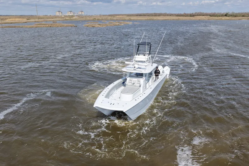 Slide: The Image of 2025 Freeman 42LR boat navigating through calm waters under a cloudy sky. - 8