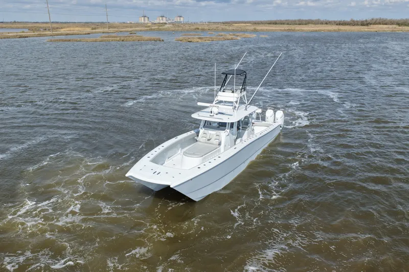 Slide: The Image of 2025 Freeman 42LR boat navigating through open waters under a cloudy sky. - 9