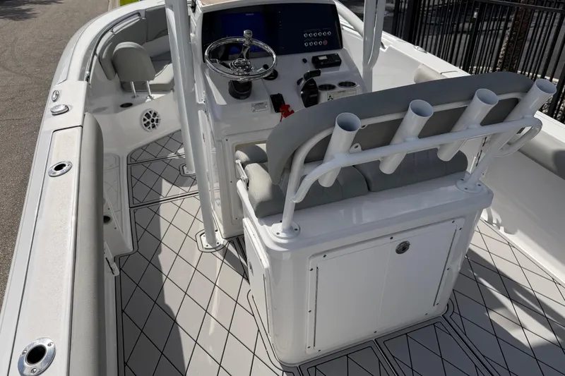 Slide: The Image of 2016 Sportsman Heritage 231 Center Console boat interior with steering wheel and rod holders. - 114