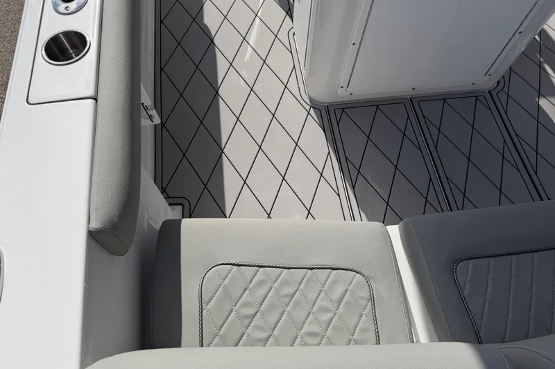 Slide: The Image of 2016 Sportsman Heritage 231 Center Console boat interior with diamond-patterned flooring and cushioned seating. - 115