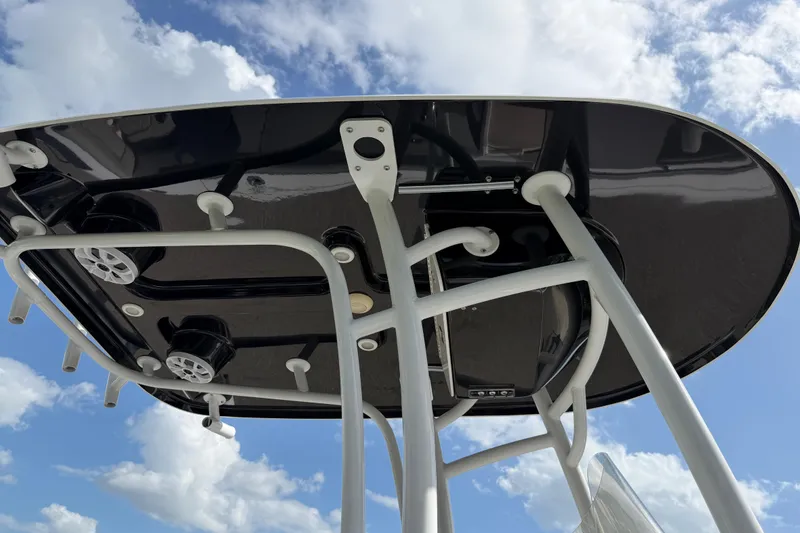 Slide: The Image of 2016 Sportsman Heritage 231 Center Console T-top against a blue sky with clouds. - 124