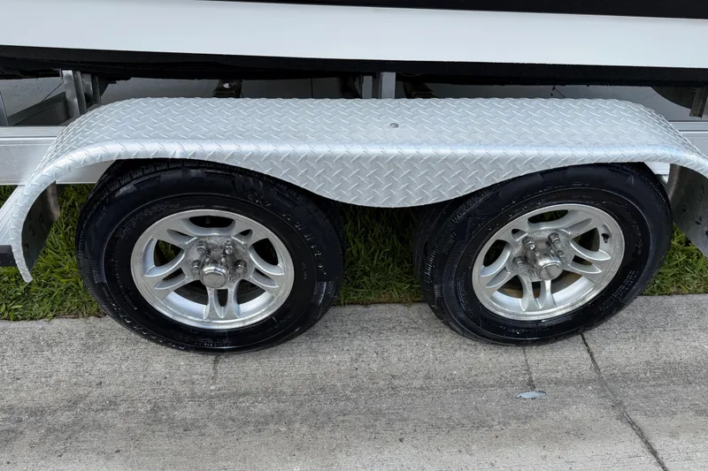 Slide: The Image of Trailer wheels of a 2016 Sportsman Heritage 231 Center Console boat on pavement. - 23