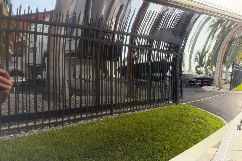 Slide: The Image of Reflection on 2016 Sportsman Heritage 231 Center Console boat, showing fence and greenery. - 27