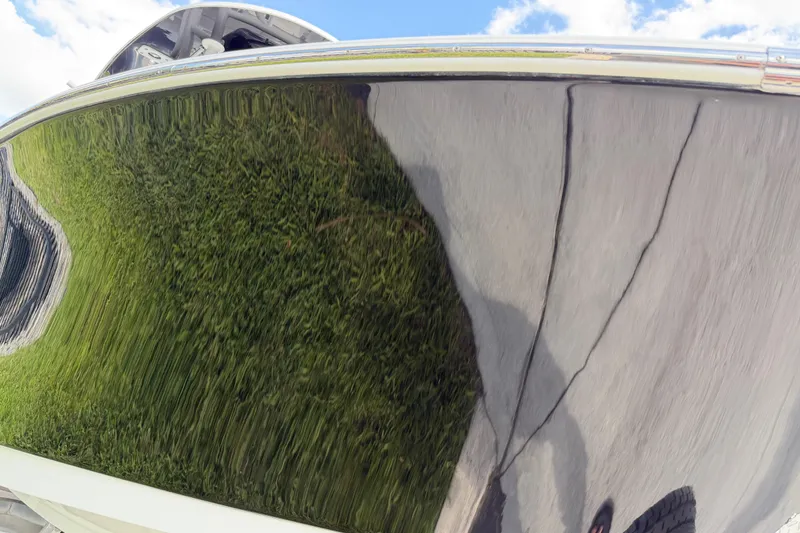Slide: The Image of Close-up of a 2016 Sportsman Heritage 231 Center Console boat hull reflecting grass. - 29