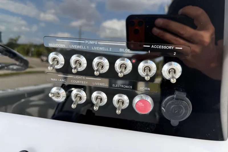 Slide: The Image of Control panel of a 2016 Sportsman Heritage 231 Center Console boat with labeled switches. - 31