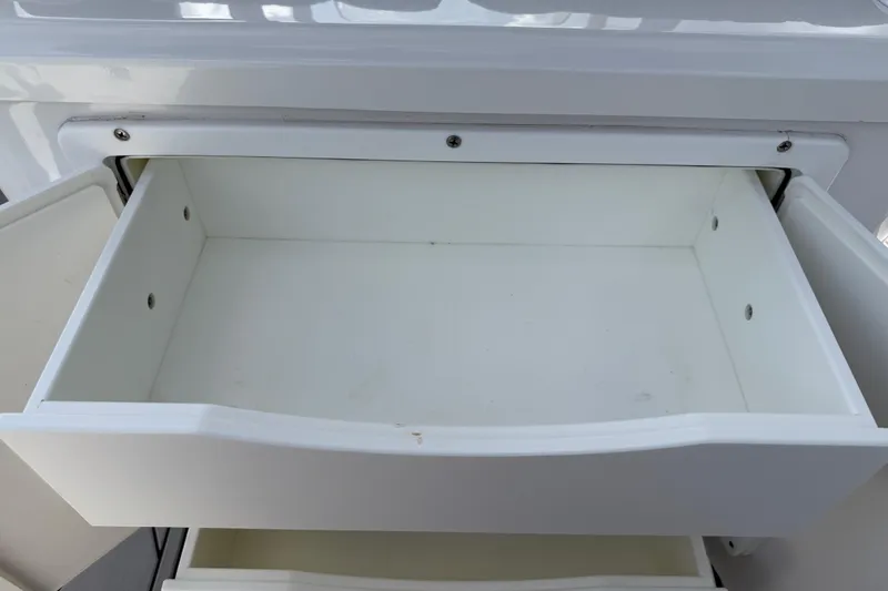 Slide: The Image of Open storage compartment on 2016 Sportsman Heritage 231 Center Console boat. - 64