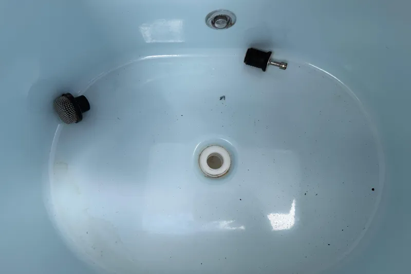 Slide: The Image of Interior of a 2016 Sportsman Heritage 231 Center Console boat, showing a clean, empty compartment. - 81