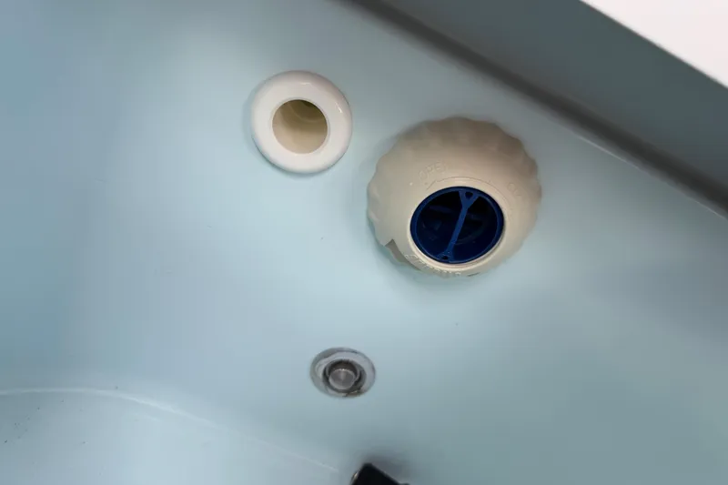 Slide: The Image of 2016 Sportsman Heritage 231 Center Console boat interior detail showing drainage and plug system. - 82