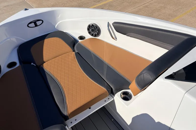 Slide: The Image of 2025 Tahoe 210 Si boat interior with tan and black seating, cup holders, and speaker. - 15