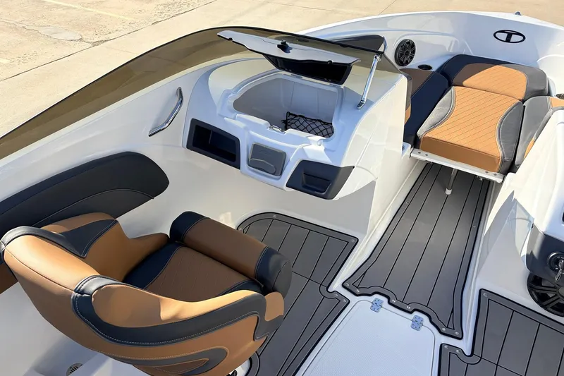 Slide: The Image of 2025 Tahoe 210 Si boat interior with tan and black seating, modern design, and sleek flooring. - 25