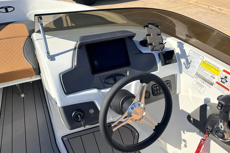 Slide: The Image of 2025 Tahoe 210 Si boat dashboard with steering wheel and control panel. - 32