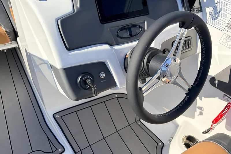 Slide: The Image of Steering wheel and dashboard of 2025 Tahoe 210 Si boat, featuring modern controls. - 34