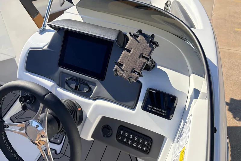 Slide: The Image of 2025 Tahoe 210 Si boat dashboard with steering wheel and control panel. - 35