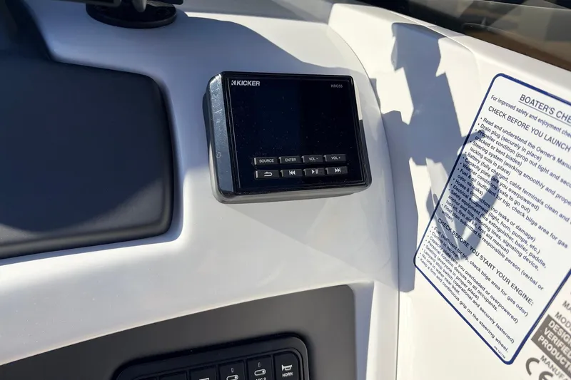 Slide: The Image of Dashboard of 2025 Tahoe 210 Si boat with Kicker stereo system and safety checklist. - 36