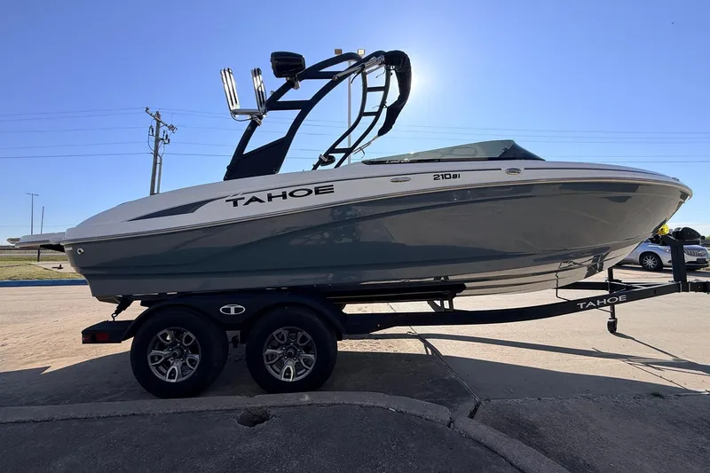 Slide: The Image of 2025 Tahoe 210 Si boat on trailer, sleek design under clear blue sky. - 4