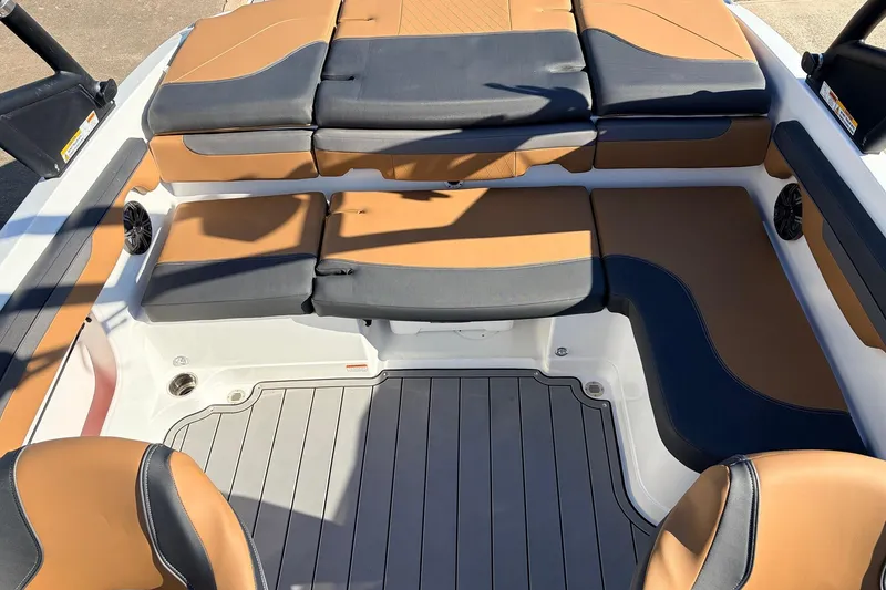 Slide: The Image of 2025 Tahoe 210 Si boat interior with tan and black seating, gray flooring. - 42