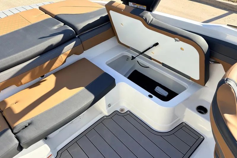 Slide: The Image of 2025 Tahoe 210 Si boat interior with open storage compartment and cushioned seating. - 44