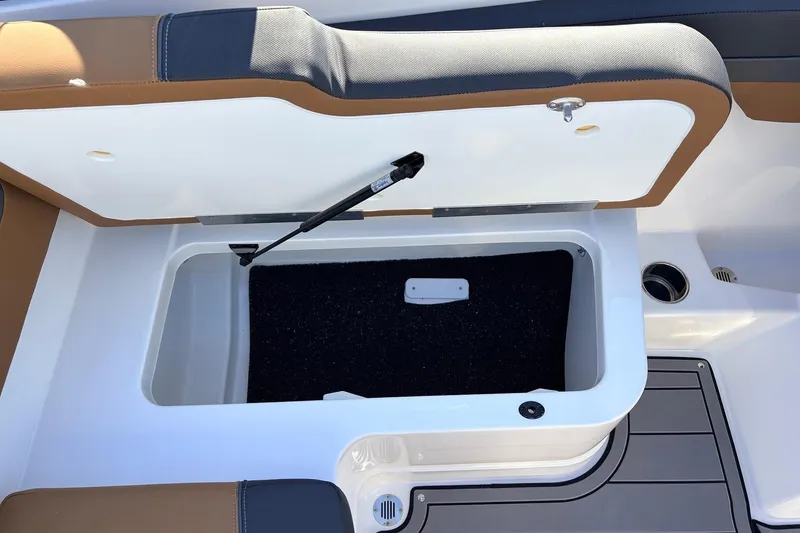 Slide: The Image of Open storage compartment in 2025 Tahoe 210 Si boat, featuring cushioned seating and sleek design. - 45