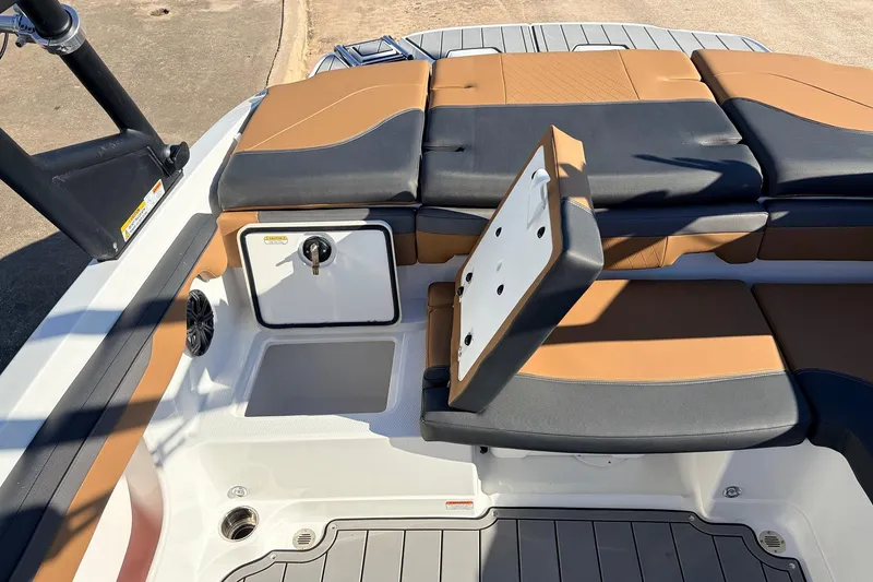 Slide: The Image of 2025 Tahoe 210 Si boat interior with open storage compartment and cushioned seating. - 48