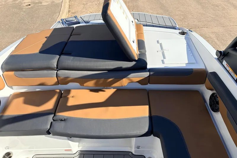 Slide: The Image of 2025 Tahoe 210 Si boat interior with tan and black seating, cup holder, and storage compartment. - 51