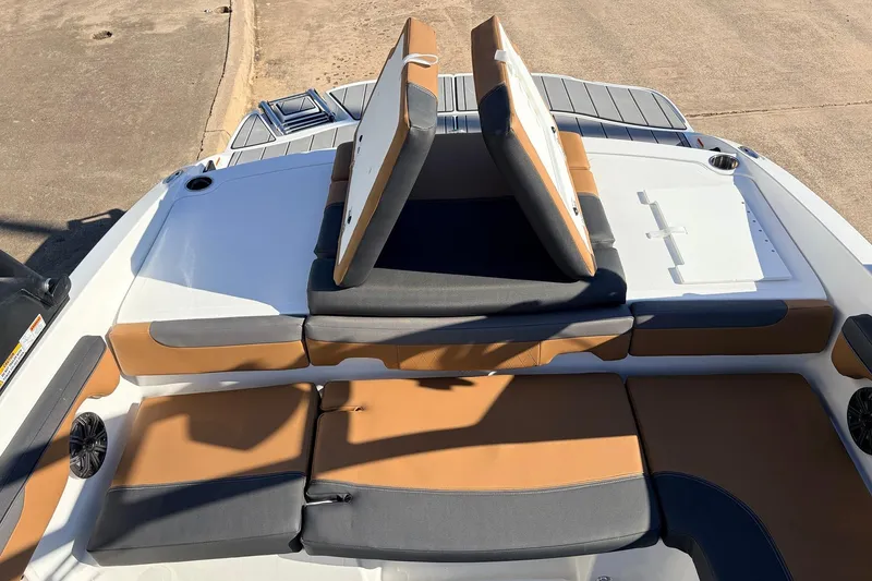 Slide: The Image of 2025 Tahoe 210 Si boat interior with tan and gray seating, open storage compartment. - 52