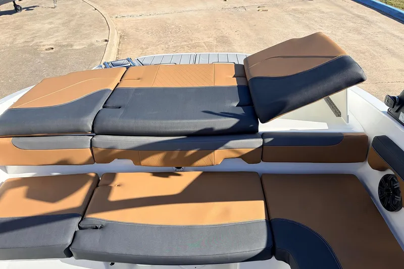 Slide: The Image of 2025 Tahoe 210 Si boat with luxurious tan and black seating on deck. - 53