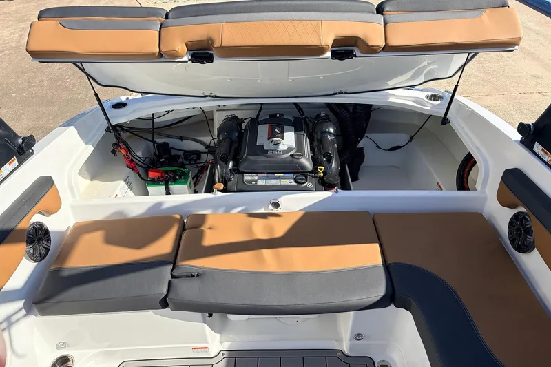Slide: The Image of 2025 Tahoe 210 Si boat engine compartment with tan and gray seating. - 54