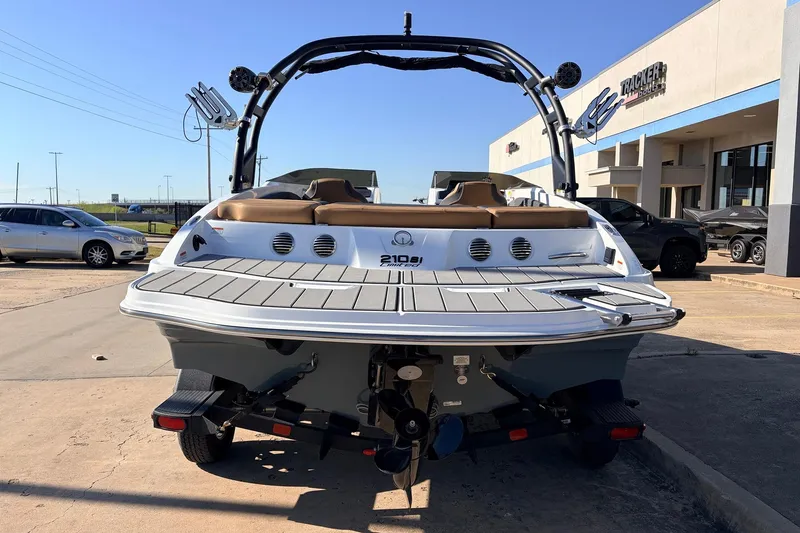 Slide: The Image of 2025 Tahoe 210 Si boat displayed at dealership, rear view with trailer. - 6