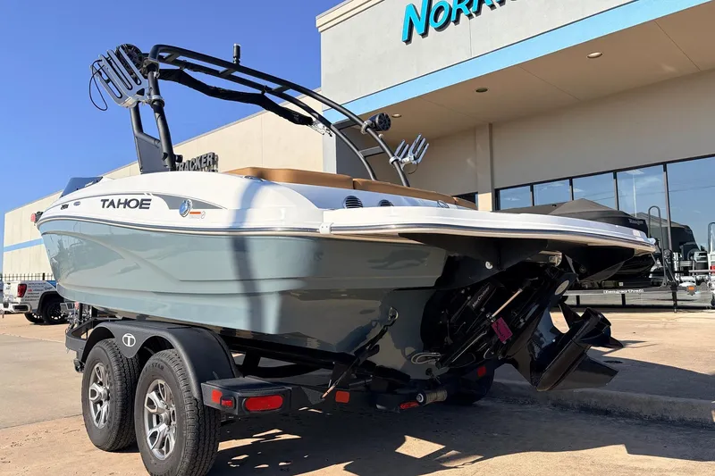 Slide: The Image of 2025 Tahoe 210 Si boat on trailer outside dealership, showcasing sleek design and modern features. - 7