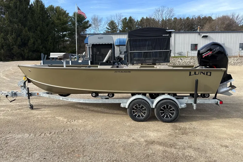 The Image of 2026 Lund 2075 Alaskan SS boat on trailer, parked outdoors. - 1