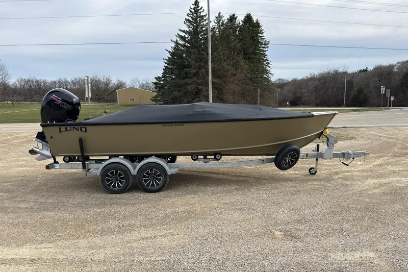 Slide: The Image of 2026 Lund 2075 Alaskan SS boat on trailer, covered, parked outdoors. - 12
