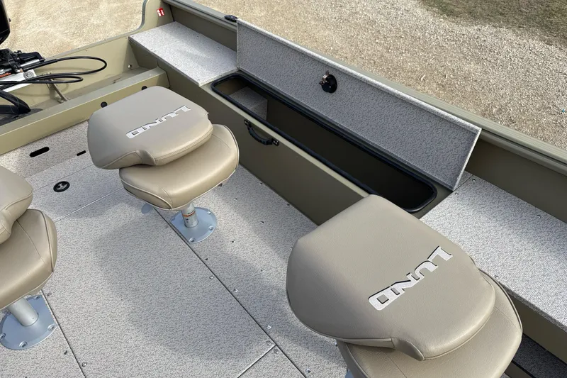 Slide: The Image of 2026 Lund 2075 Alaskan SS boat interior with beige seats and storage compartment. - 9