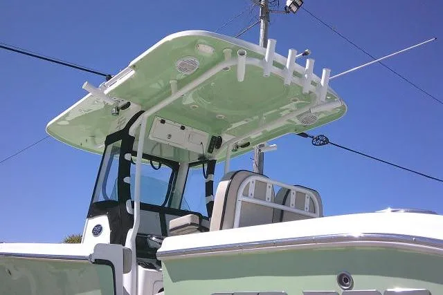Slide: The Image of 2022 Sea Pro 259 Center Console boat with T-top and rod holders under clear blue sky. - 10