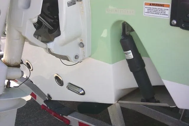 Slide: The Image of 2022 Sea Pro 259 Center Console boat on trailer, showing engine and hydraulic components. - 16