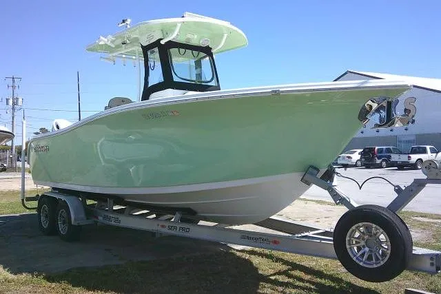 Slide: The Image of 2022 Sea Pro 259 Center Console boat on trailer, light green hull, outdoor setting. - 3