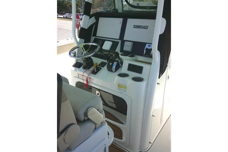 Slide: The Image of 2022 Sea Pro 259 Center Console boat dashboard with steering wheel and Simrad electronics. - 60