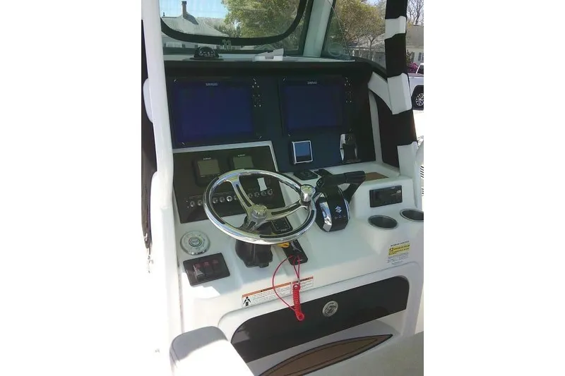 Slide: The Image of 2022 Sea Pro 259 Center Console boat dashboard with steering wheel and controls. - 66