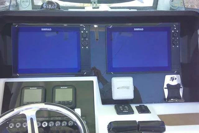 Slide: The Image of 2022 Sea Pro 259 Center Console dashboard with dual Simrad displays and controls. - 73