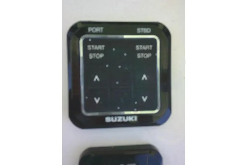 Slide: The Image of Control panel of a 2022 Sea Pro 259 Center Console boat with Suzuki branding. - 76