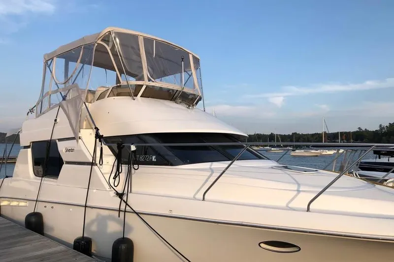 The Image of 1998 Silverton 351 Sedan yacht docked at marina under clear blue sky. - 0