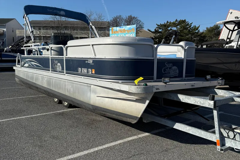Slide: The Image of 2012 SunCatcher LV 228 Cruise pontoon boat on trailer in parking lot. - 2