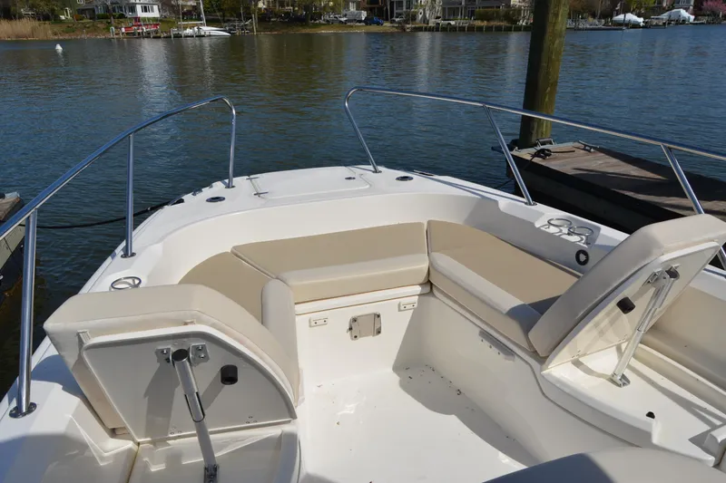Slide: The Image of 2021 Boston Whaler 270 Dauntless boat interior with beige seating by the water. - 11